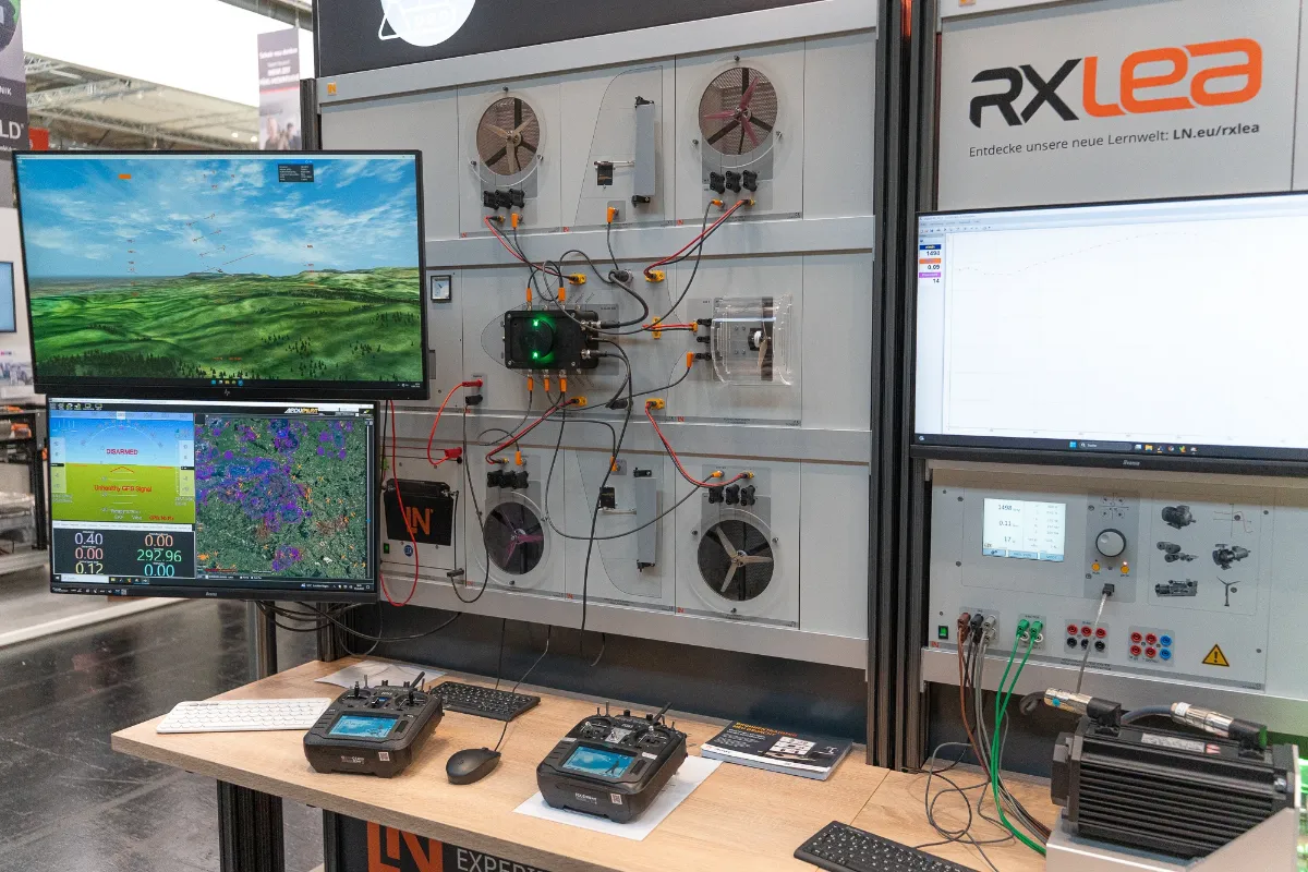 Training wall with flight simulator, mission planning and remote controls at the trade fair booth